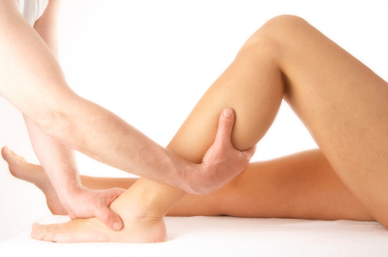 massage of a female calf muscle on white